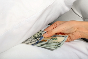 Woman hiding money under pillow