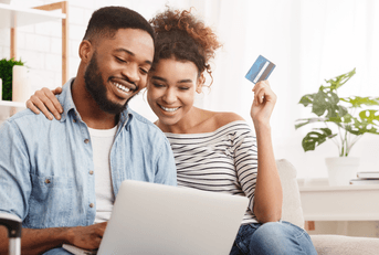 Smiling couple looking at a laptop