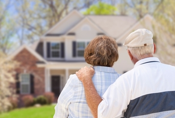 retired senior couple looking at house 
