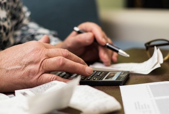 Senior woman checking bills at home