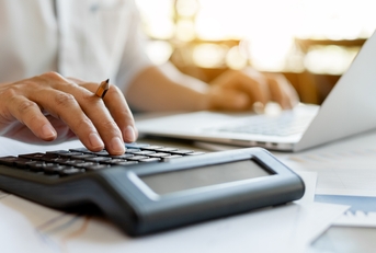businessman pressing on calculator