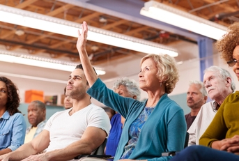 Woman Asking Question At Neighborhood Meeting In Community Center 