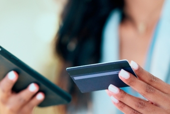 Woman holding a credit card and phone