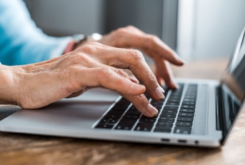 senior woman typing on laptop