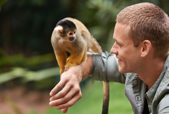 man interacting with a little monkey