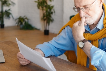 senior male studying paper works