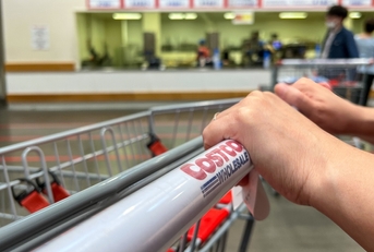 hands pushing a costco carton
