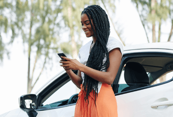 person on phone outside car