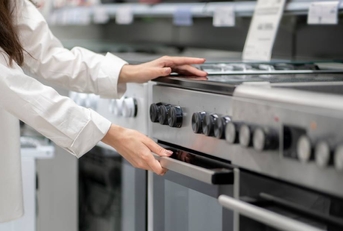 woman buying a new kitchen stove in the electronics retail store