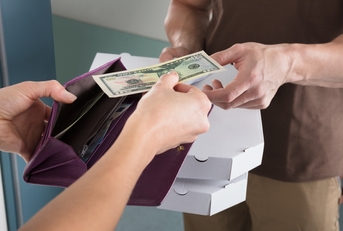 woman giving us dollar note for the pizza