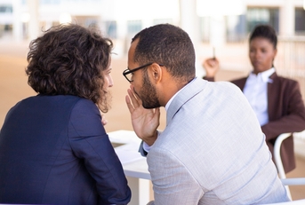 employees gossiping about young female colleague