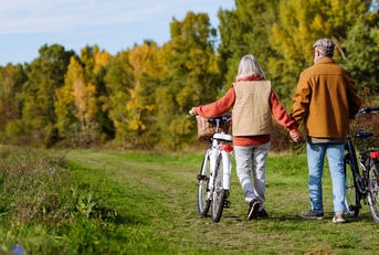 seniors pushing their bikes side by side