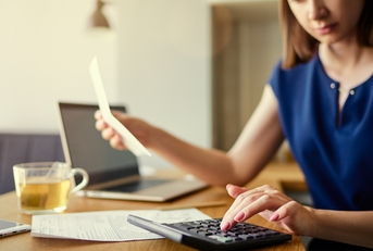 woman using laptop and calculator
