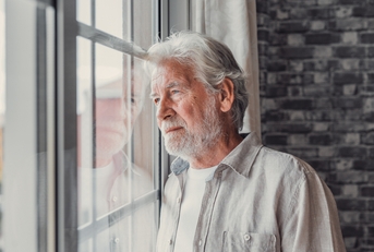 senior man looking in distance out of window