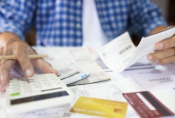 man sitting at desk calculate receipt of expenses