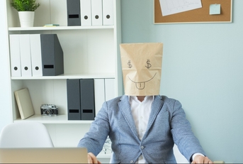 man at desk with bag on head