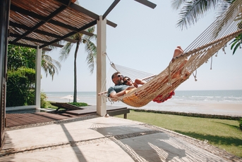 couple relaxing in a hammock by the beach