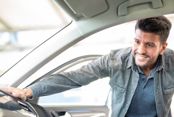 Man taking taking look at car in showroom