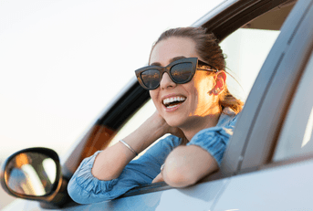 person-leaning-out-of-car-window-smiling