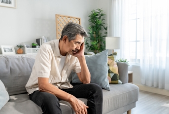 depress man sitting alone in living room at home