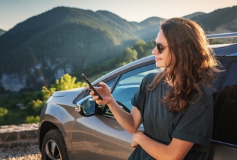 Woman outside car using phone