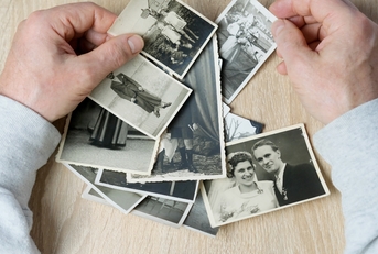 man looks through his old photographs