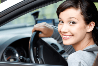 person in car with hand on steering wheel