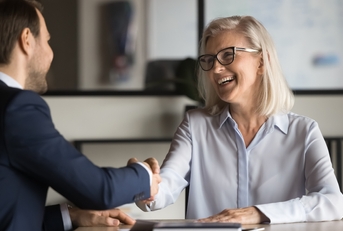 businesswoman shaking hands with younger business colleague