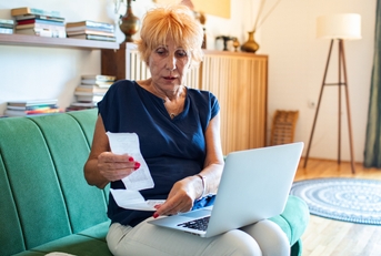 elderly woman reviewing receipts 