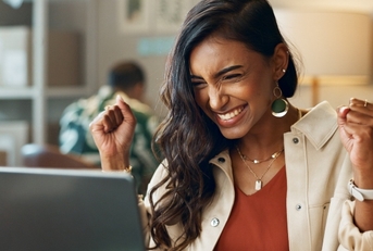 Triumphant woman looking at computer