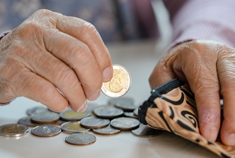 senior woman holding counting coin
