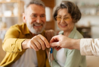 Realtor giving senior couple key to new house