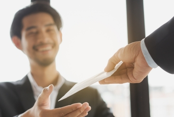 Happy office worker receiving extra money