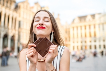 woman with dark chocolate bar standing outdoors
