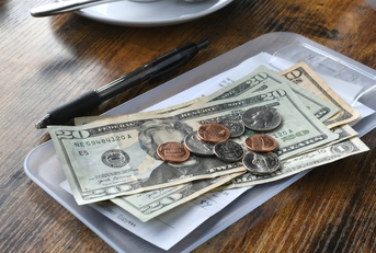 paying bill tab with money