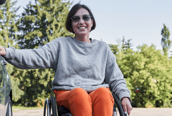 Woman using a wheelchar getting into a car