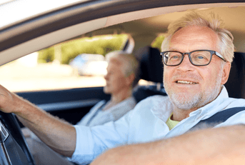 An older driver rests his elbow on the car window.