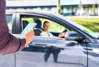 A man uses his phone to order a rideshare service. 