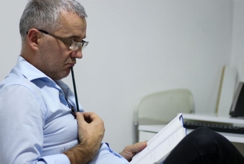 Worried middle-aged businessman having problems at workplace, solving job issues, doing paperwork.