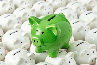 Green piggy bank standing out among white piggy banks 