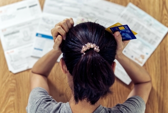stressed woman holding head worry about bills