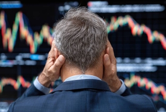 A distressed businessman observing volatile stock market trends
