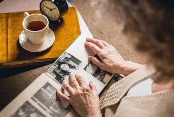 elderly woman looks at the picture in the album