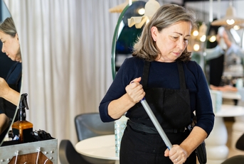 elderly female hairdresser cleaning