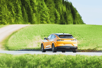 New car driving in green hills