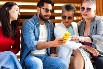 Group of diverse people using smartphone outdoors