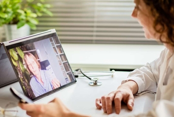 woman using laptop and taking her blood pressure