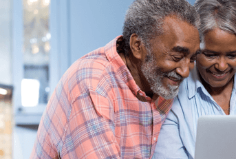 smiling seniors on laptop