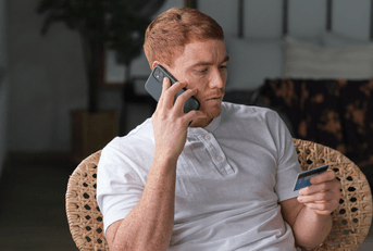 person on phone with credit card