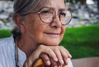 close up of 70 year old woman on sitting on a park bench
